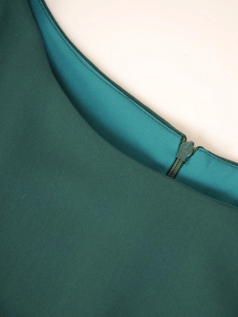 Elegancka sukienka trapezowa w kolorze butelkowej zieleni – pionowe zaszewki wysmuklające sylwetkę 34703